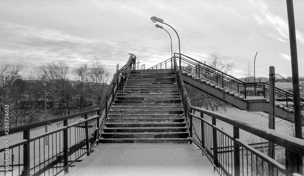 Pedestrian bridge over the railway. Stairs. Black and white