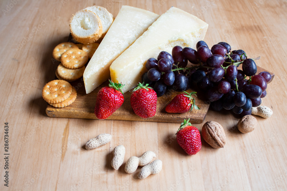 Cheese and Red Strawberries. Healthy food. Vegetarian food. The grapes are blue. Vegetable food. Parmesan food. Copyspace