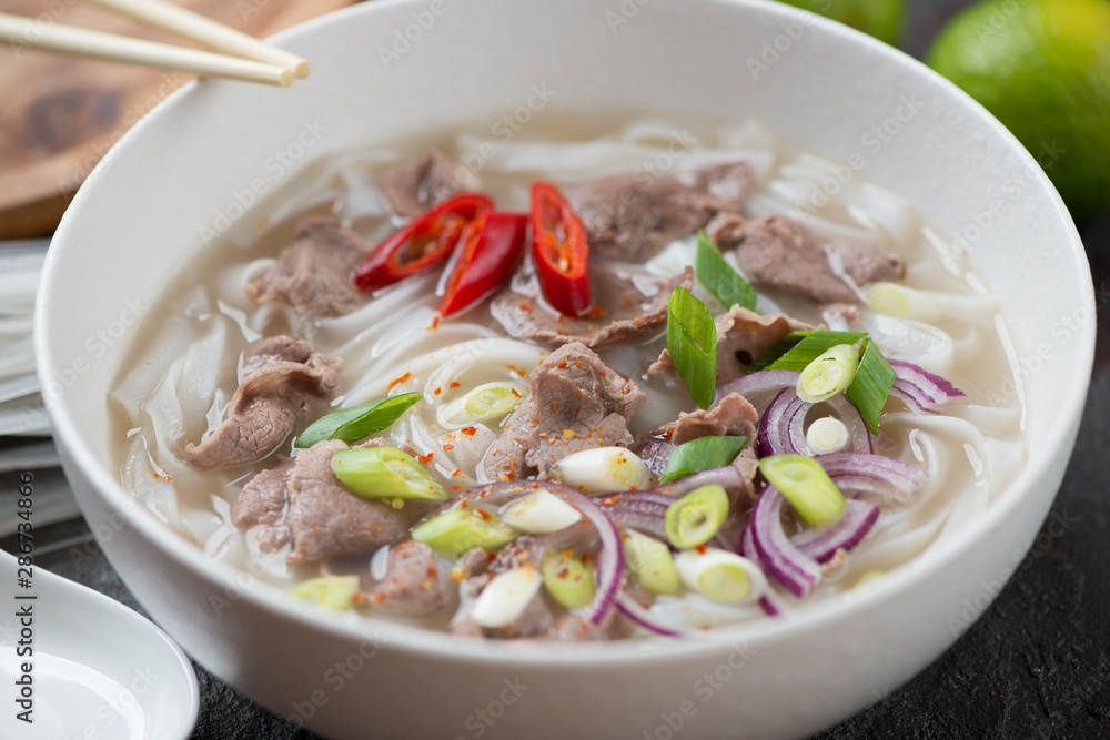 Closeup of a white bowl with traditional vietnamese pho bo soup, selective focus Closeup of a white bowl with traditional vietnamese pho bo soup, selective focus