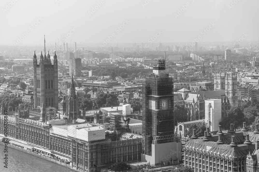 Aerial view of London with Westminster Bridge, Palace of Westminster and Big Ben being renovated in the distance.
