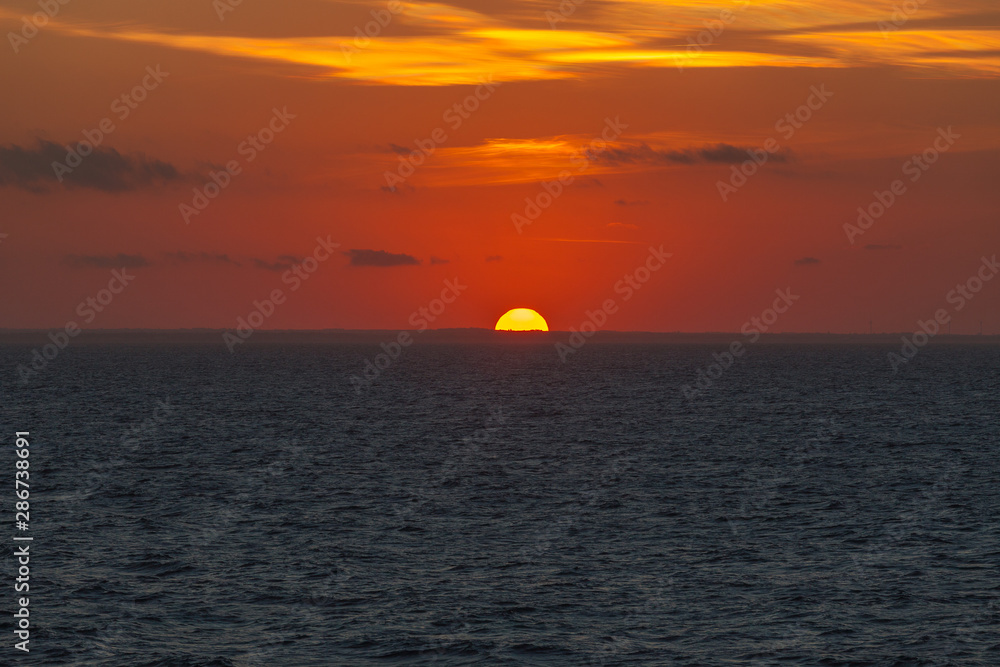Sunset behind the profile of the Adriatic coast that colors the sky with orange