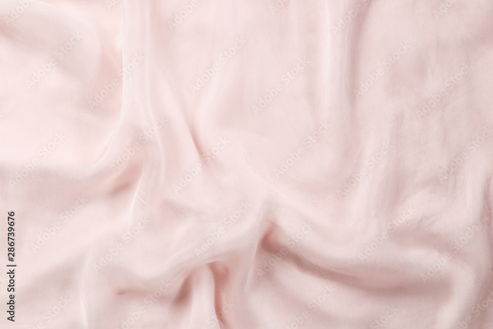 Soft smooth pink silk fabric background. Fabric texture.
