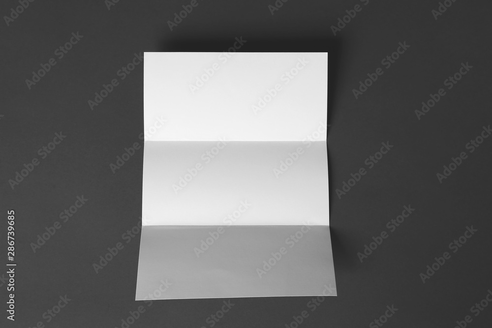 Blank brochure on dark grey background, top view. Mock up for design Blank brochure on dark grey background, top view. Mock up for design
