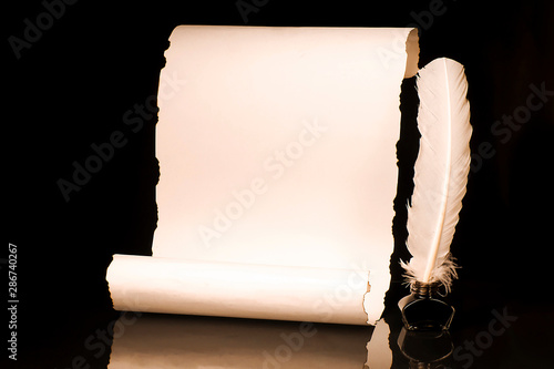 Unrolled papyrus scroll with inkwell and quill pen