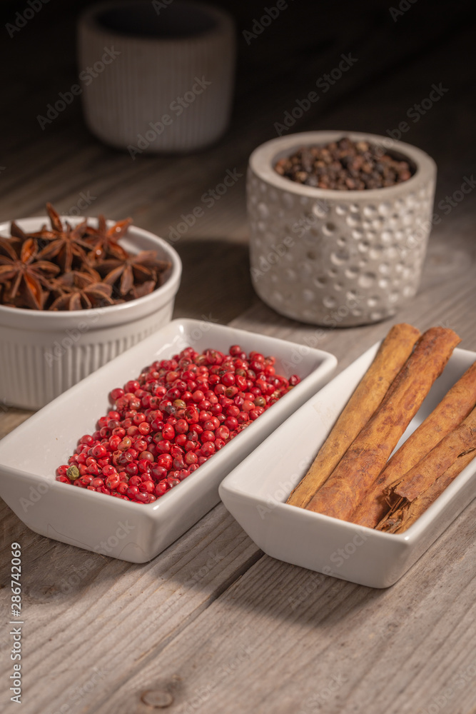 assortment of spices in pottery on a rustic table assortment of spices in pottery on a rustic table