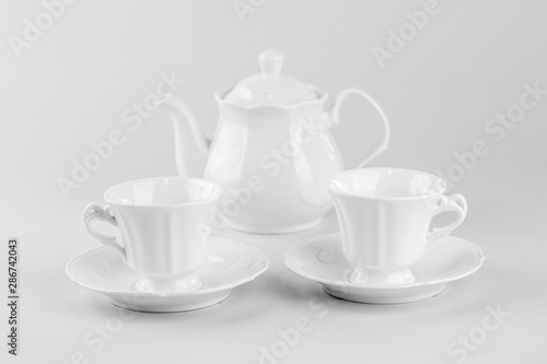 Cup of tea with teapot isolated on white background