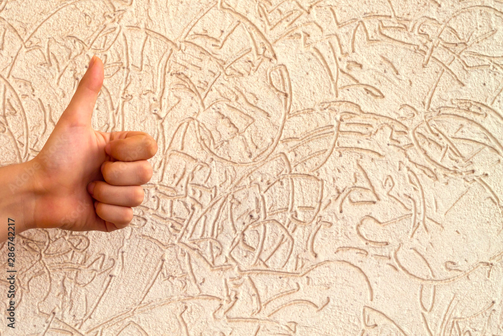 Hand with thump up in front of stone wall Hand with thump up in front of stone wall
