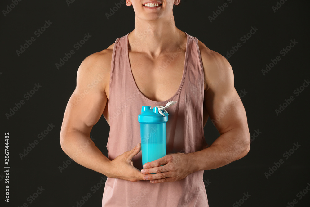 Athletic young man with protein shake on black background, closeup Athletic young man with protein shake on black background, closeup