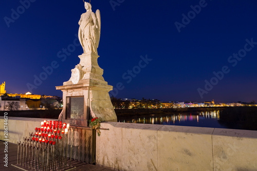 Cordoba Spain 2 2014 Candles and statue of the Archangel of St. Gabriel on the Roman bridge.