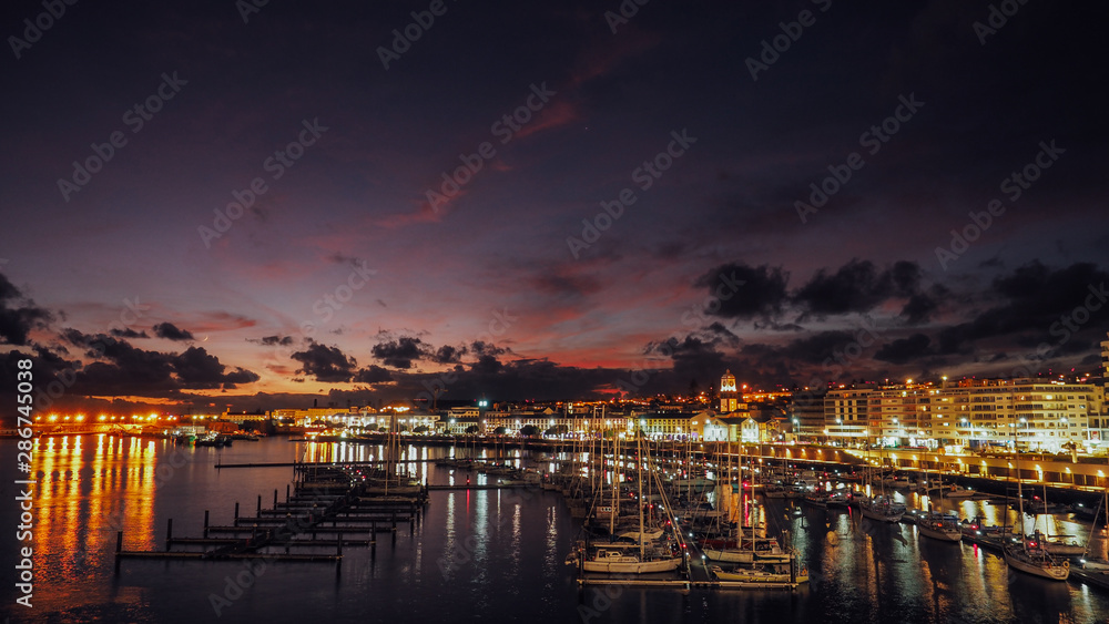 Night view of harbor at Ponta Delgada, Azores at Sao Miguel Island at epic sunset. Ocrober 10, 2018. Azores, Portugal.