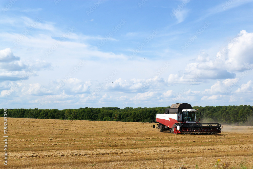 combine harvester working on wheat field under cloudy sky combine harvester working on wheat field under cloudy sky