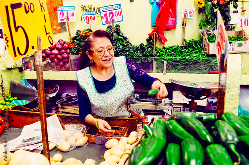 Candid portrait of woman selling vegetables in stall photo