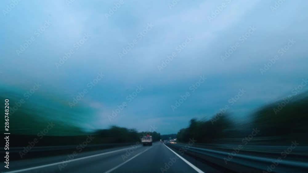Hyperlapse video from a car's dashboard driving along ahighway during an overcast rainy day Hyperlapse video from a car's dashboard driving along ahighway during an overcast rainy day