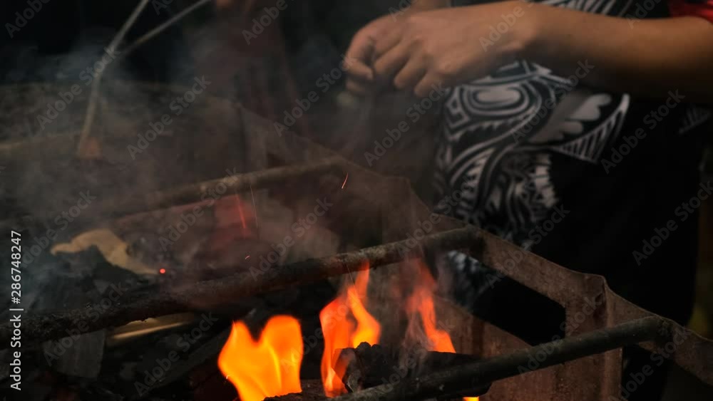 Close-up medium shot of people preparing a barbeque fire in a grill Close-up medium shot of people preparing a barbeque fire in a grill