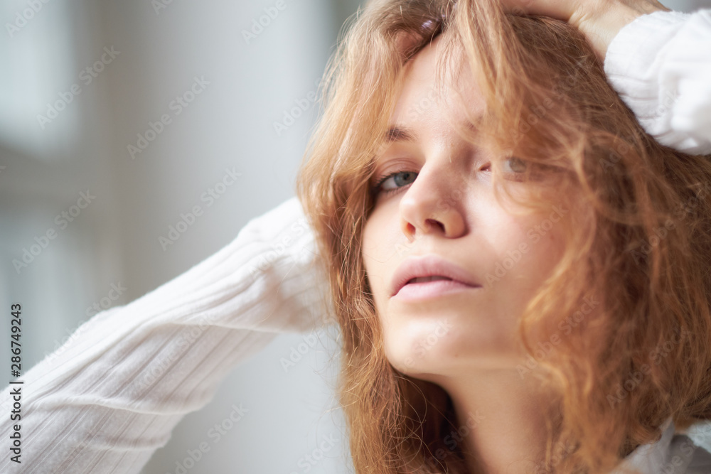 portrait of a beautiful curly girl. the mysterious face of a woman at the window. portrait of a beautiful curly girl. the mysterious face of a woman at the window.