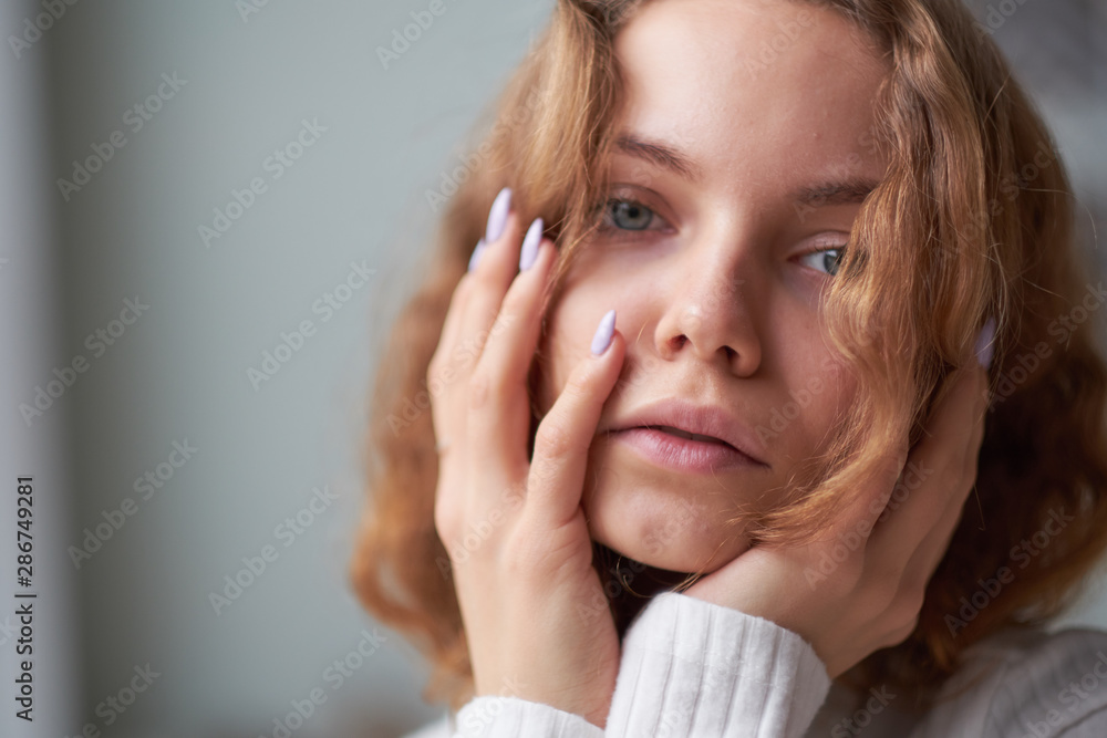 portrait of a beautiful curly girl. the mysterious face of a woman at the window. portrait of a beautiful curly girl. the mysterious face of a woman at the window.