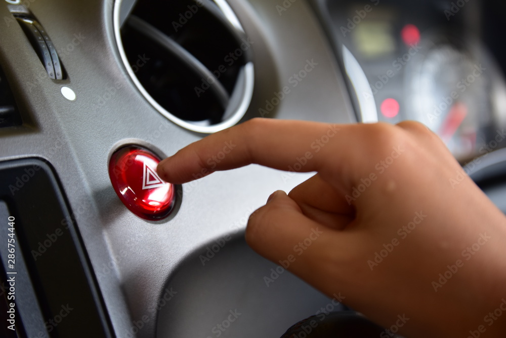 Finger hitting car emergency red light button in car