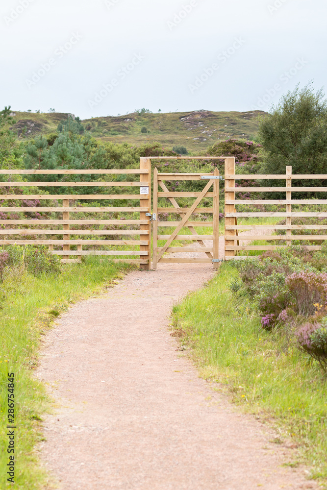 Walking path with closed wooden gate