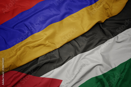 waving colorful flag of palestine and national flag of armenia.