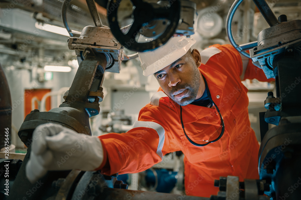 Uniformed employee with gloves handling machinery Uniformed employee with gloves handling machinery