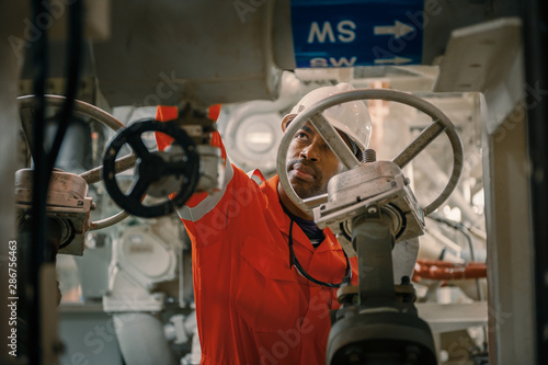 Employee inspect machinery on offshore vessel