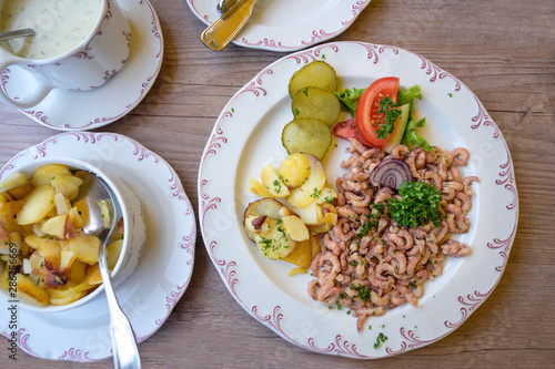 north sea crabs with fried potatoes and parsley garnish, the aromatic seafood is a typical delicacies on the coast in friesland, northern germany, high angle view from above