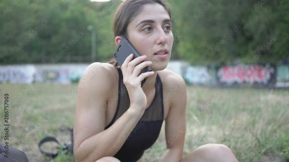 girl before training in the stadium, talking on the phone and smiling girl before training in the stadium, talking on the phone and smiling