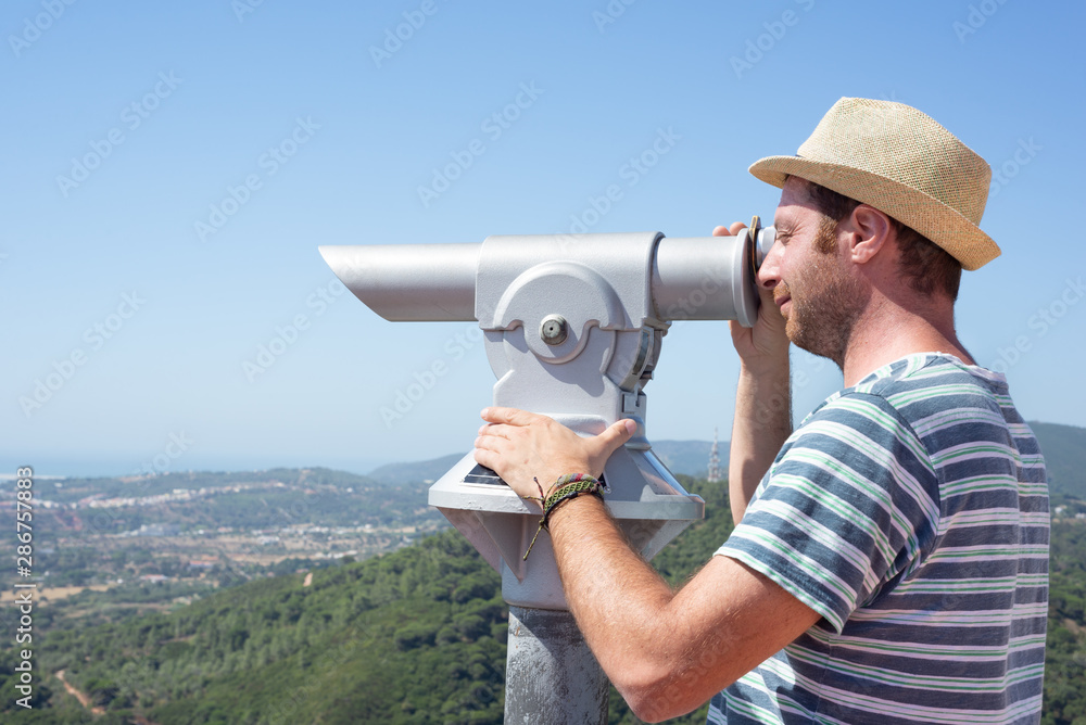 Male tourtist using a telescope. Summer holidays. 