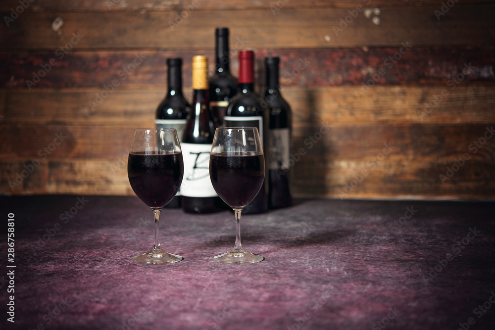 Red Wine in Glasses with Bottles in Background