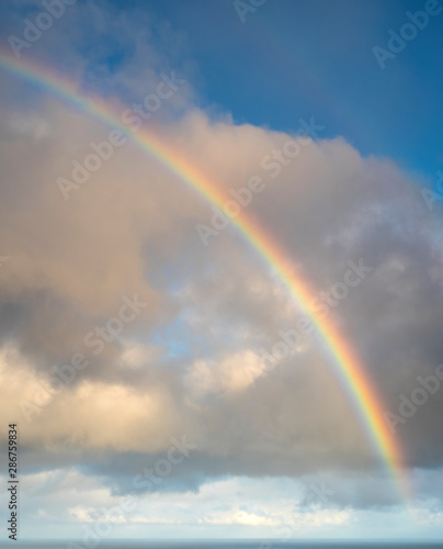 Isolated rainbow in the sky with clouds on Faroe island. Big size.