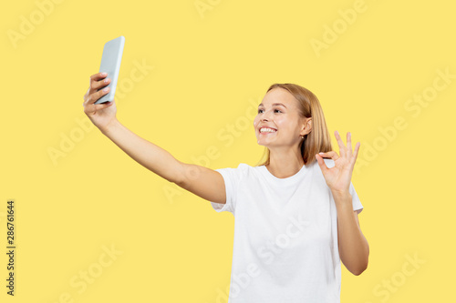 Fotografía Caucasian young woman's half-length portrait on yellow studio background
