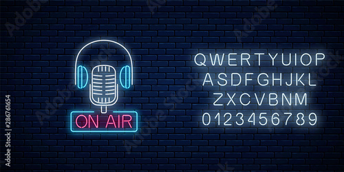 Neon on the air sign with retro microphone and headphones with alphabet. Glowing signboard of radio station