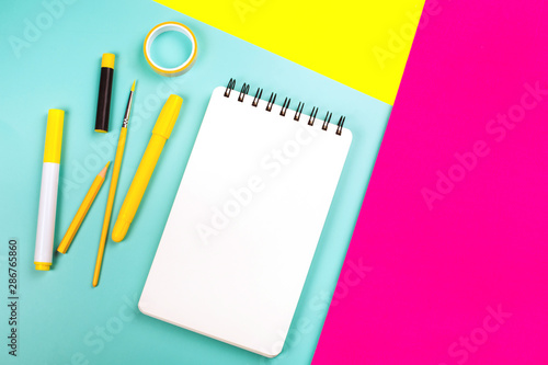 School supplies on yellow and pink background with copy space. Back to school concept.