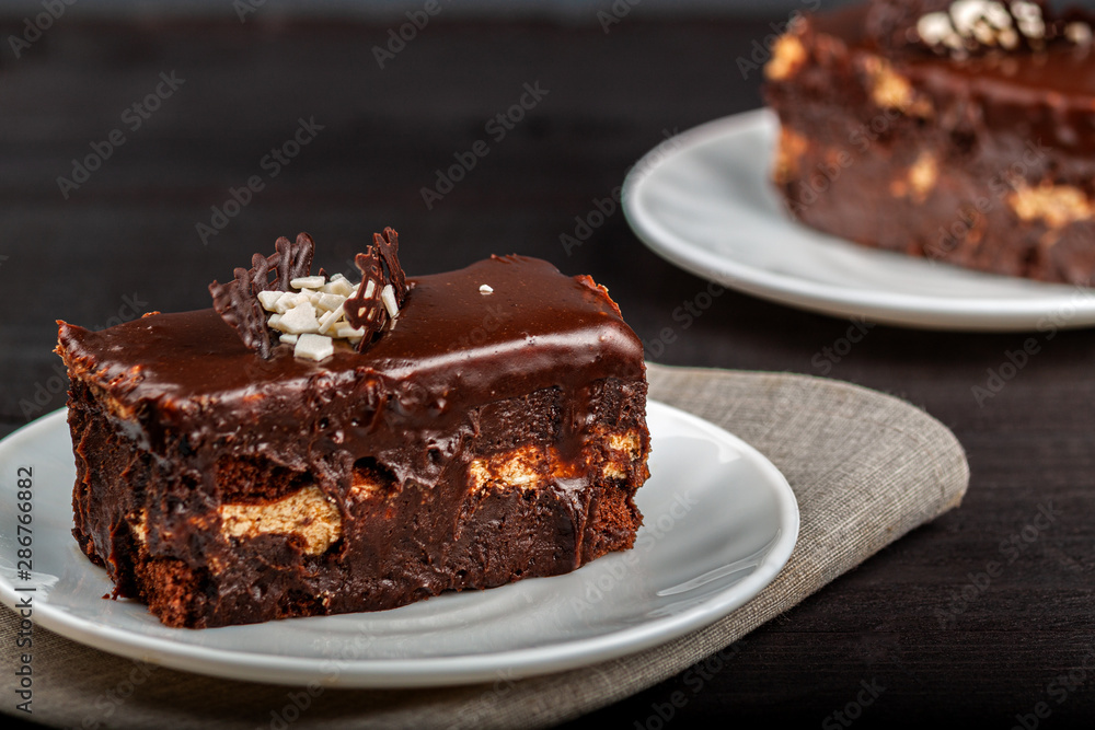 Dish with a slice of chocolate cake stands on a wooden table Dish with a slice of chocolate cake stands on a wooden table