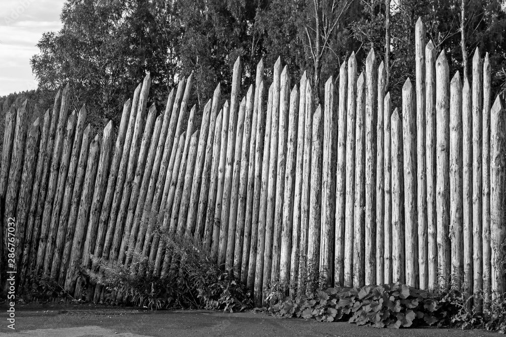 a very old wooden fence made of logs is a good example of ancient architecture