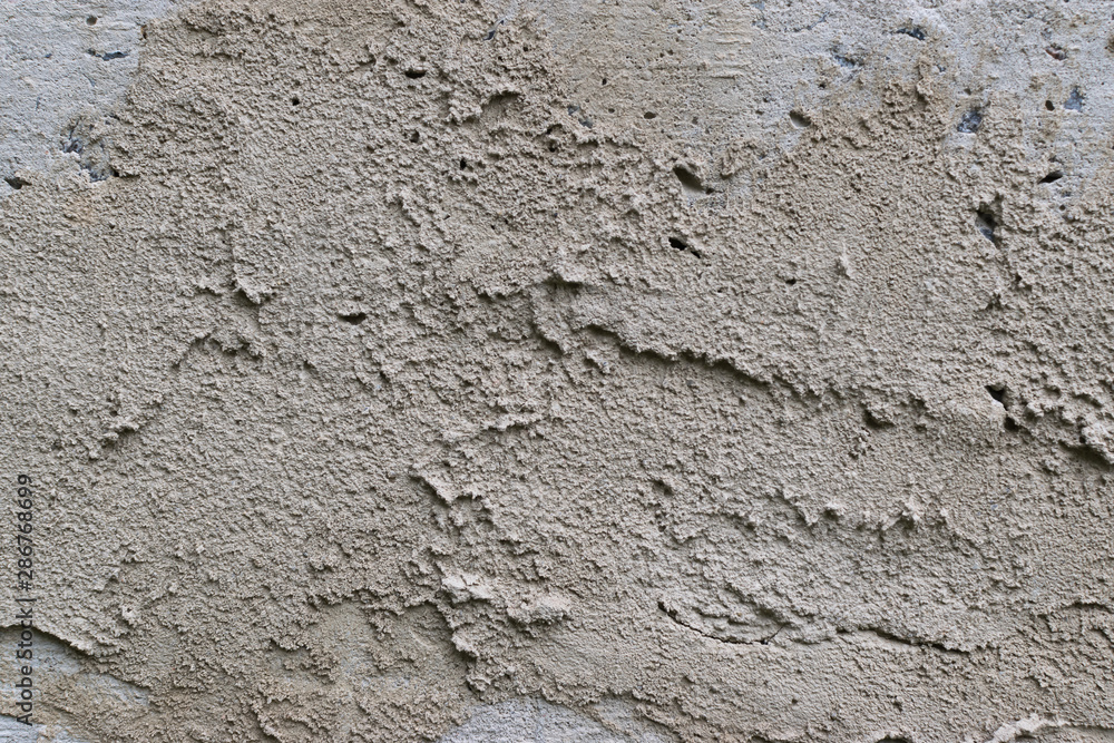 Old gray concrete wall with yellow and brown spots as an abstract background