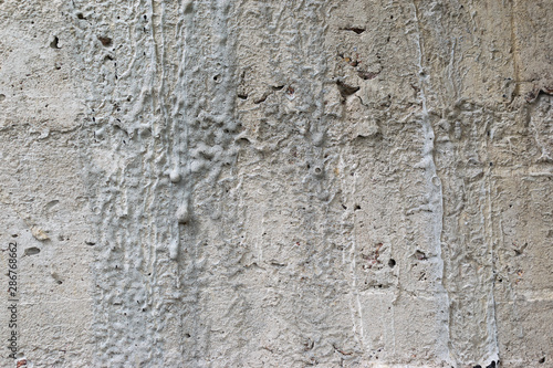 Old gray concrete wall with yellow and brown spots as an abstract background