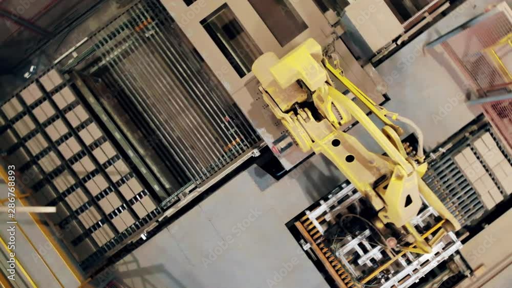 A machine works at a factory, putting boxes on a line. A machine works at a factory, putting boxes on a line.