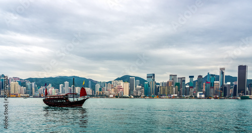 Chinese traditional junk boat in front of Hong Kong skyline © Dawid