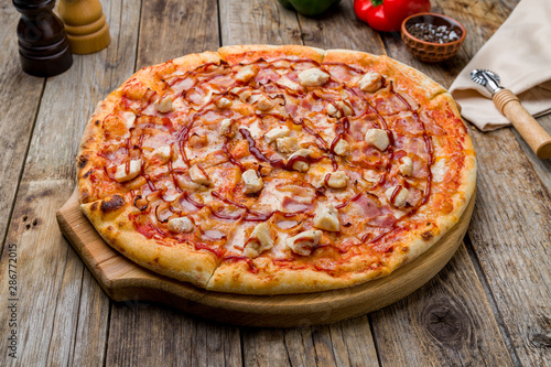 Pizza with chicken meat and barbecue sauce on old wooden table