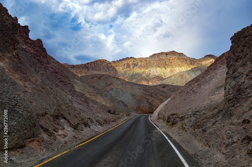 The sun illuminates a single peak down the road of Death Valley National Park