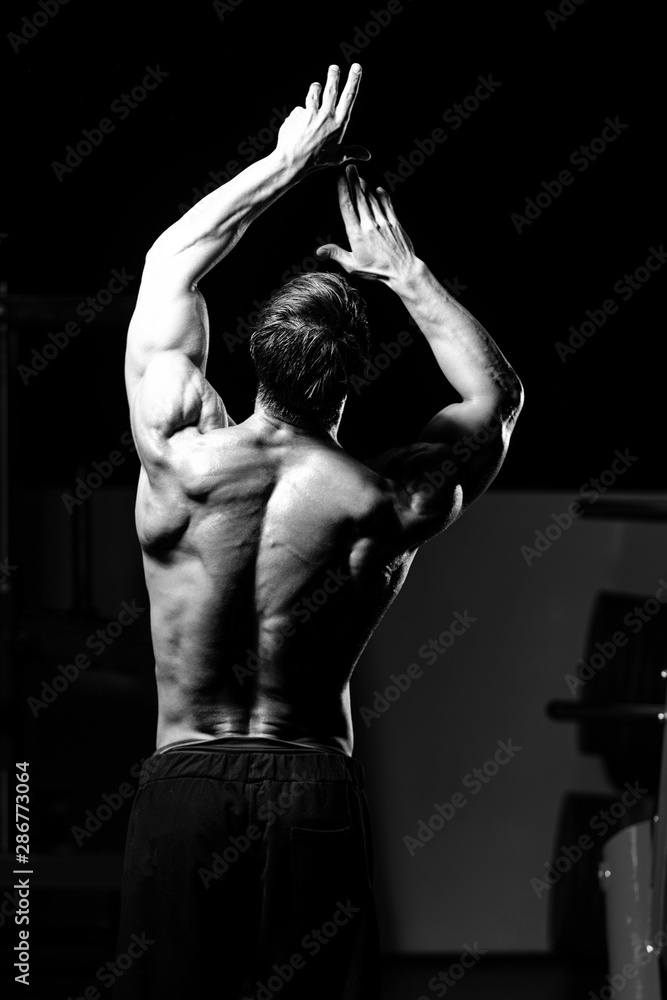 Foto Stock Middle Age Man Bodybuilder Flexing Back Pose | Adobe Stock