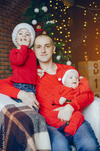 Cute family have fun in decorating room. Handsome father with little son. Family in a red sweaters