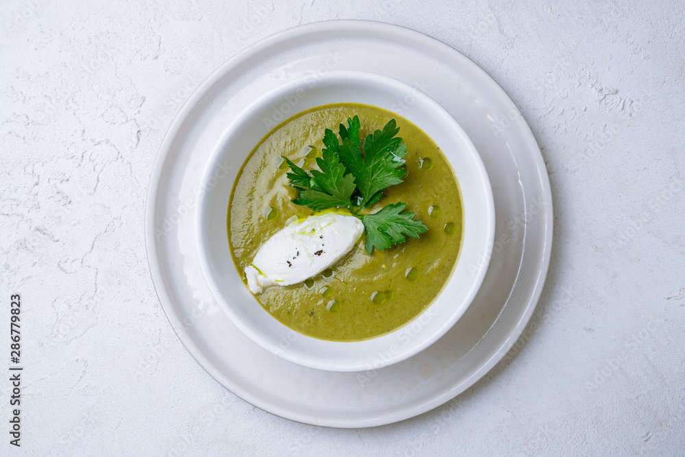 Cream of broccoli soup on white concrete table Cream of broccoli soup on white concrete table