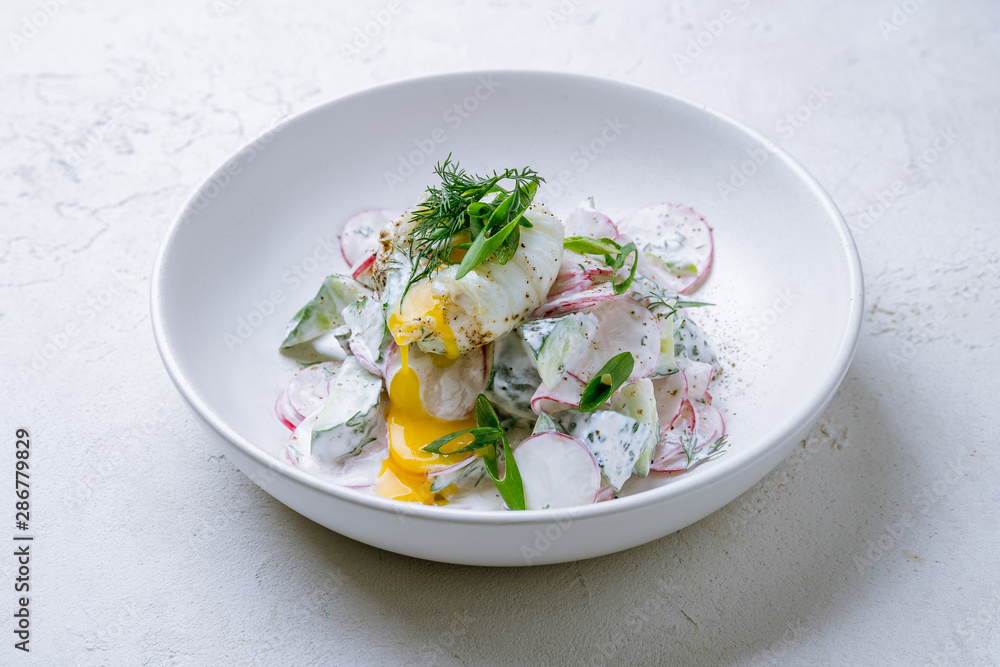 Vegetable salad with poached egg on white concrete table Vegetable salad with poached egg on white concrete table