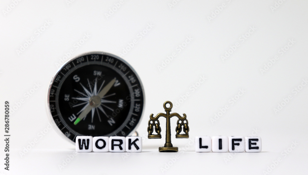 A miniature scale between WORK word and LIFE word on white cubes in front of the compass.