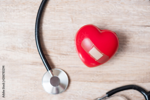 Stethoscope with Red heart shape on wooden background. Healthcare, life Insurance and World Heart Day concept