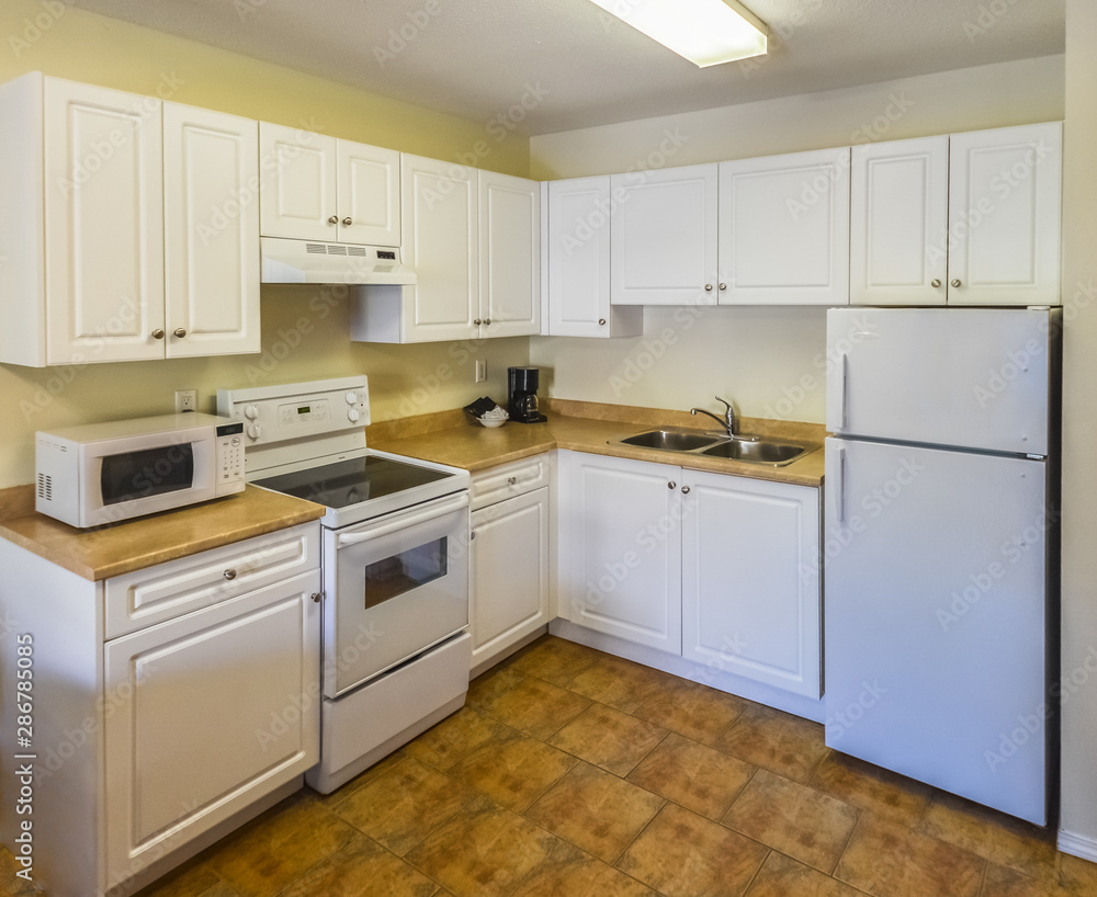 Conventional white kitchen with the table and chairs in dinner area. Conventional white kitchen with the table and chairs in dinner area.