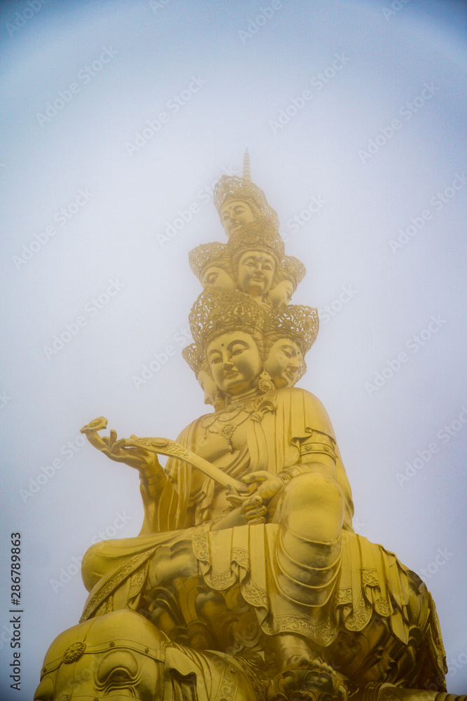 Golden Puxian statue of Mt. Emei on a foggy day