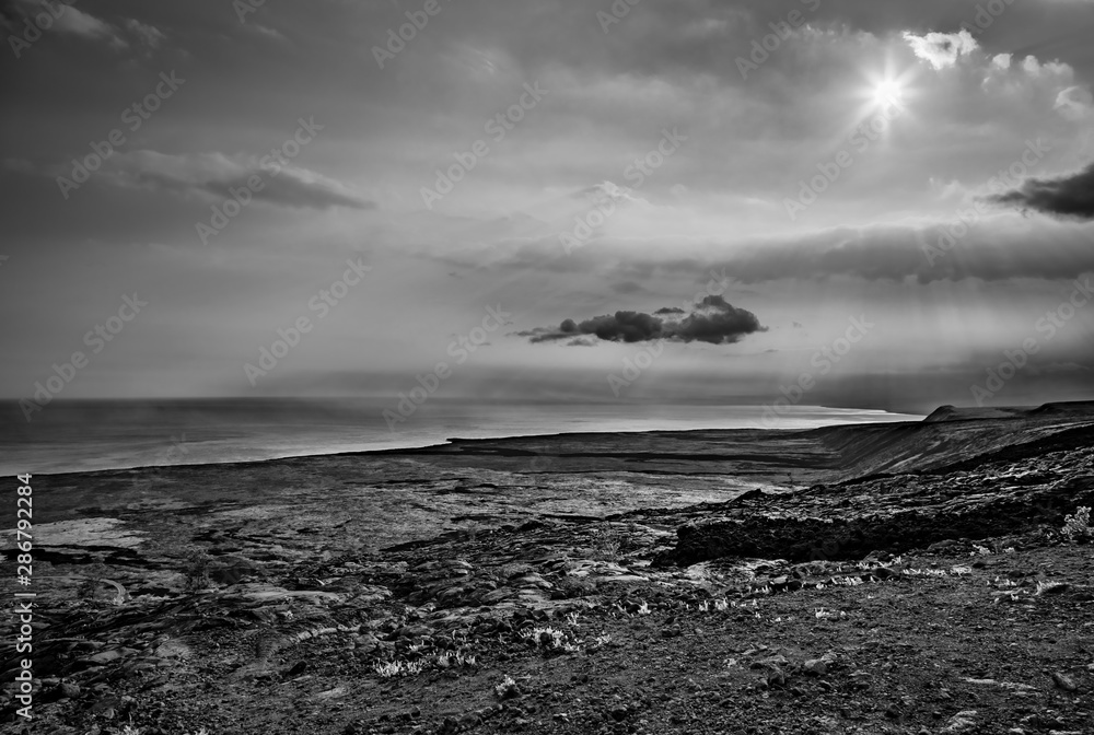 Black and white of lava rock and dark clouds